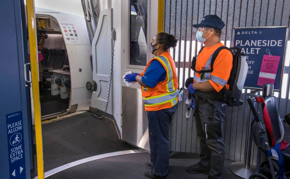 Delta Airlines cleaning personnel prepare to disinfect another airplane as COVID-19 safety prec ...