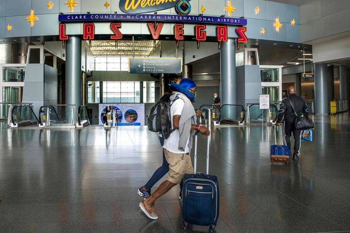 Passengers make their way through Terminal 1 as COVID-19 safety precautions continue at McCarra ...