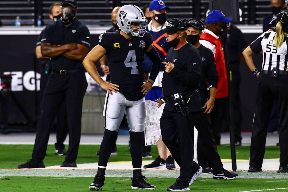 Las Vegas Raiders quarterback Derek Carr (4) talks with head coach Jon Gruden during the third ...