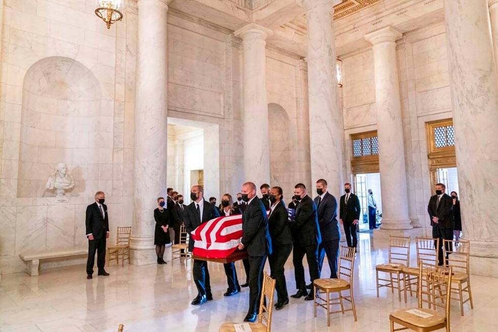 The flag-draped casket of Justice Ruth Bader Ginsburg, carried by Supreme Court police officers ...