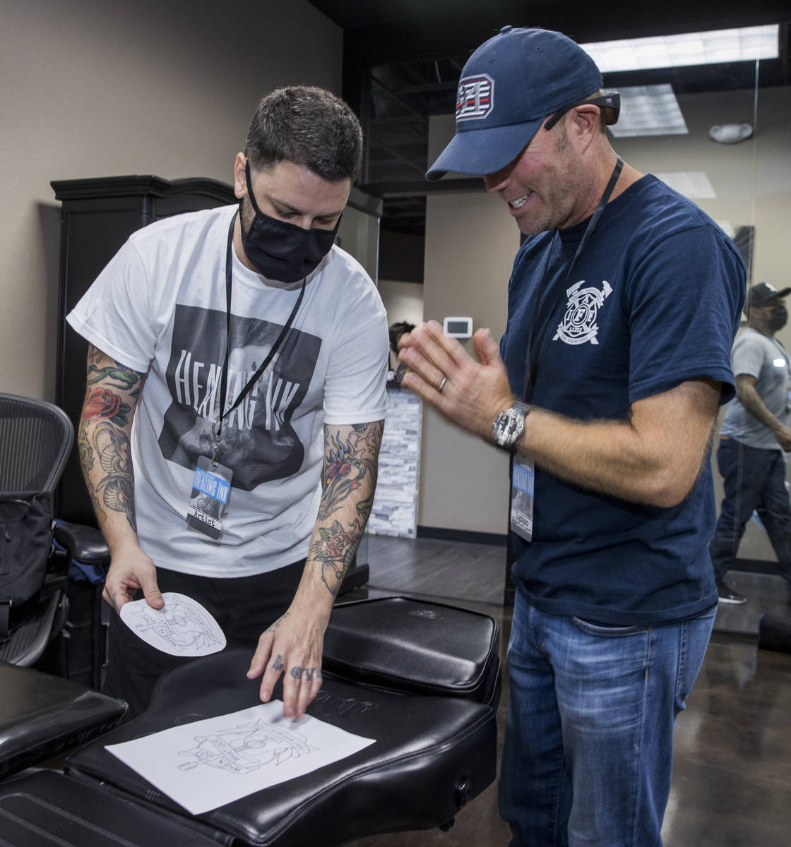 Tattoo artist Jim Sylvia, left, shows a sketch to Dean McAuley as Route 91 shooting survivors a ...