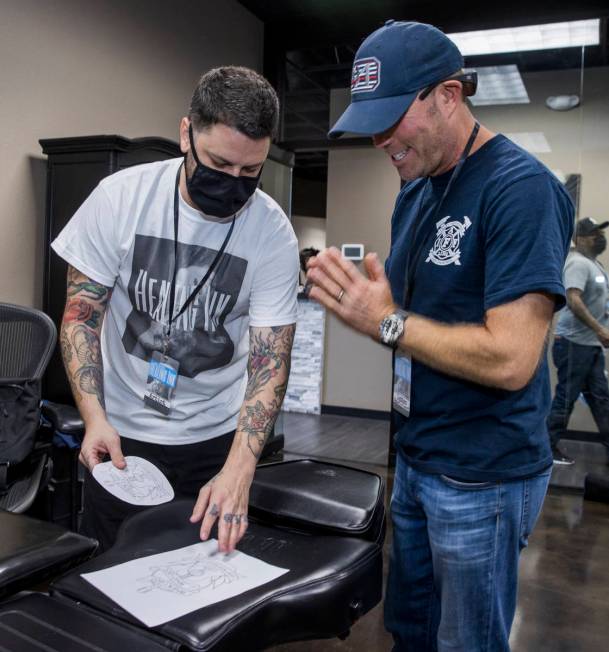 Tattoo artist Jim Sylvia, left, shows a sketch to Dean McAuley as Route 91 shooting survivors a ...
