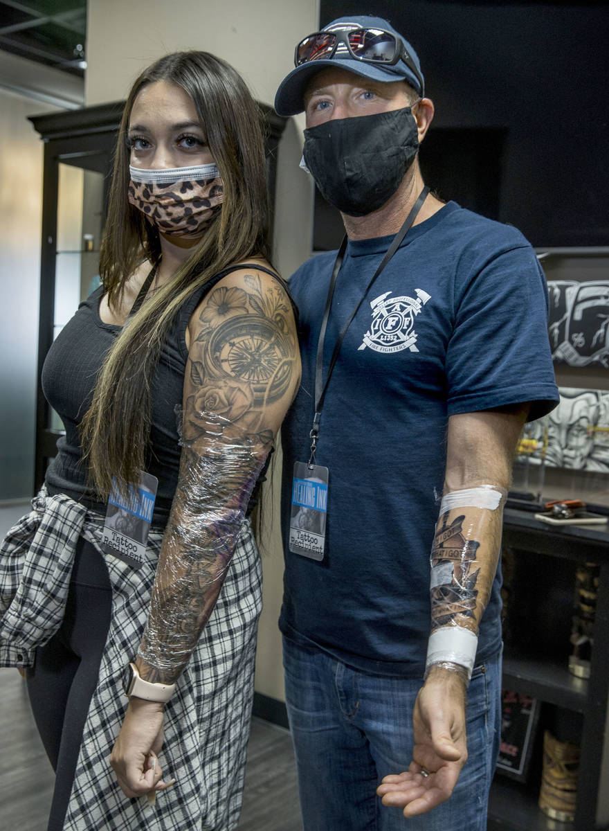 Natalia Baca, left, with Seattle firefighter Dean McAuley show off their finished tattoos as Ro ...