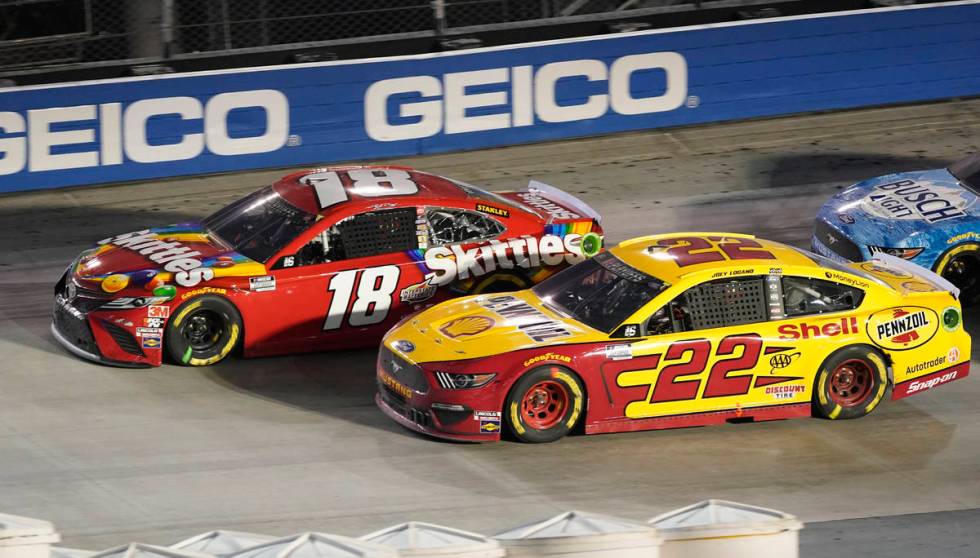 Kyle Busch (18) and Joey Logano (22) drive out of Turn 4 during the NASCAR Cup Series auto race ...