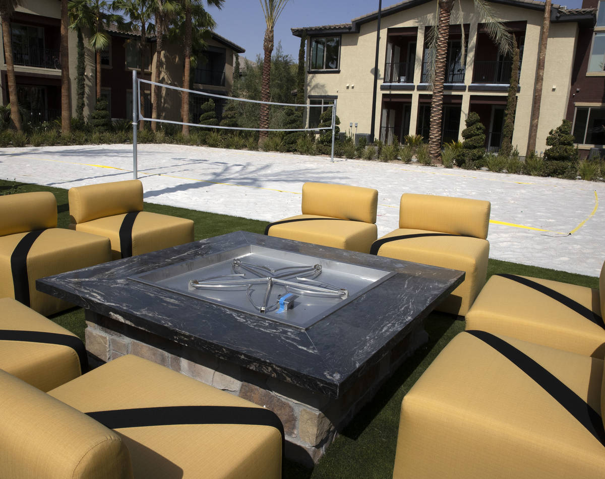 A fire pit and sand volleyball court are seen at the Tuscan Highlands apartment complex under c ...