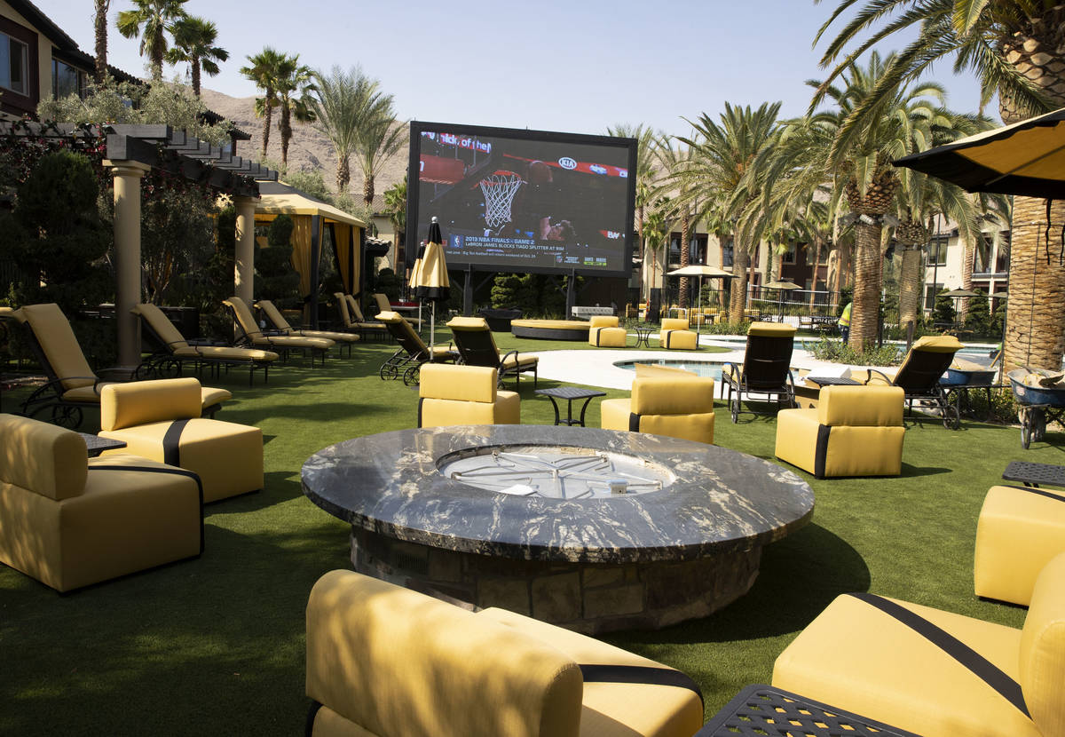 A fire pit and a giant television are seen at a pool area at the Tuscan Highlands apartment com ...