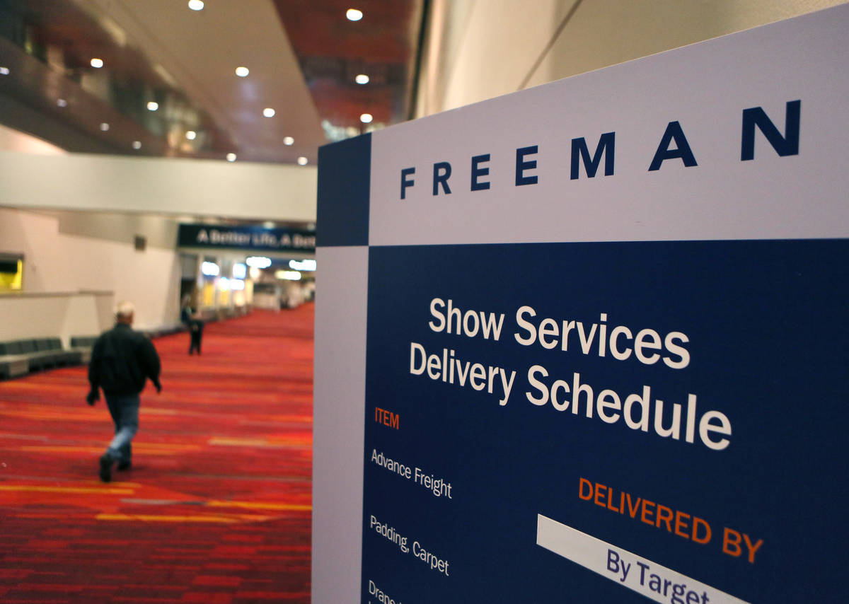 A man walks by a Freeman delievery schedule sign during preparations for the Consumer Electroni ...