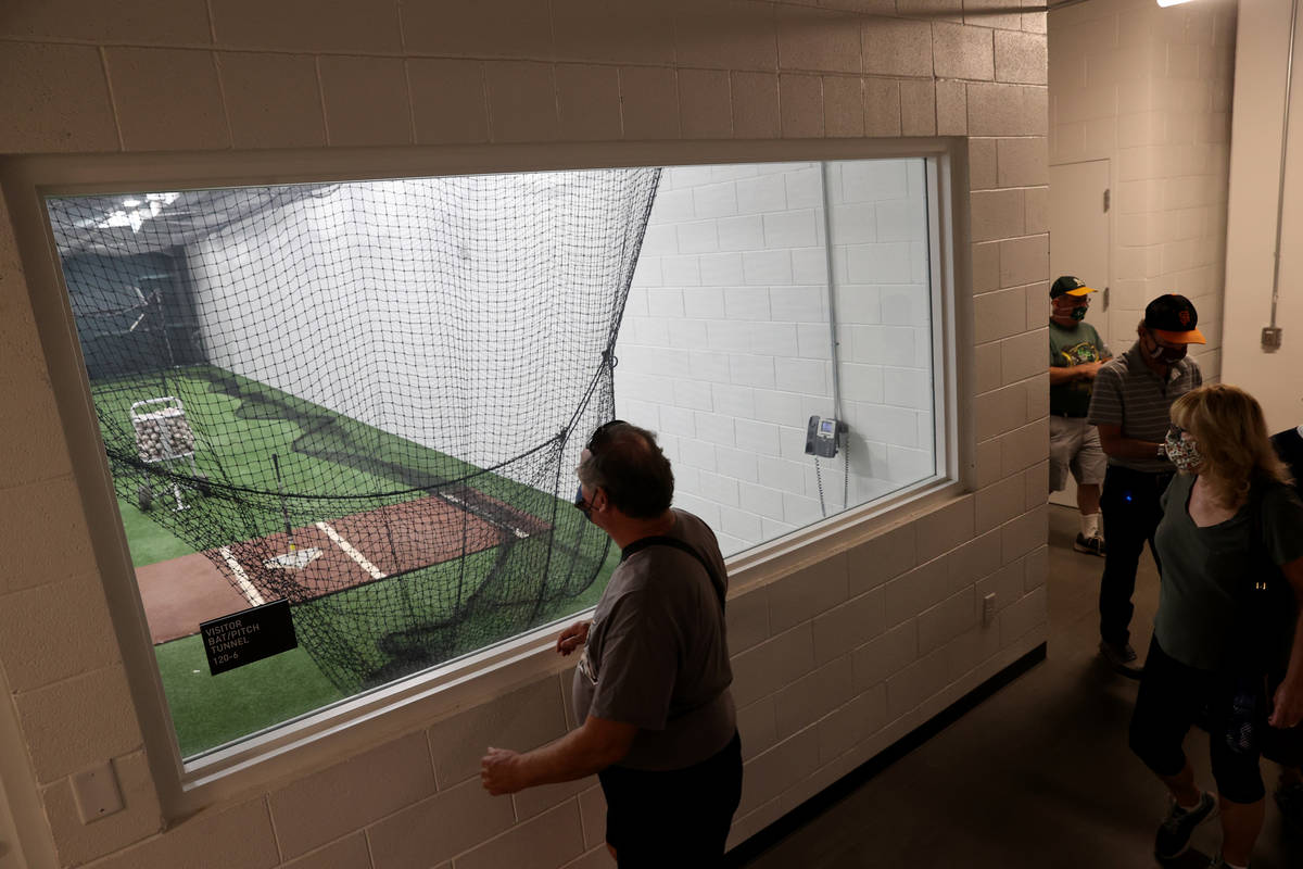 Fans check out the visitor batting cage during a tour of Las Vegas Ballpark in Summerlin Friday ...