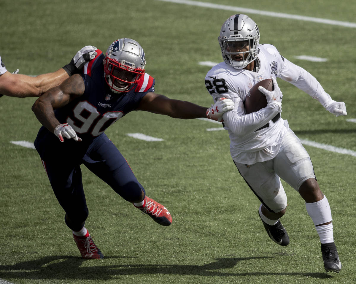 Las Vegas Raiders running back Josh Jacobs (28) turns the corner around New England Patriots li ...