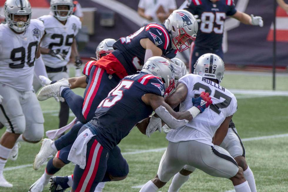 New England Patriots running back Rex Burkhead (34) leaps over Las Vegas Raiders cornerback Tra ...