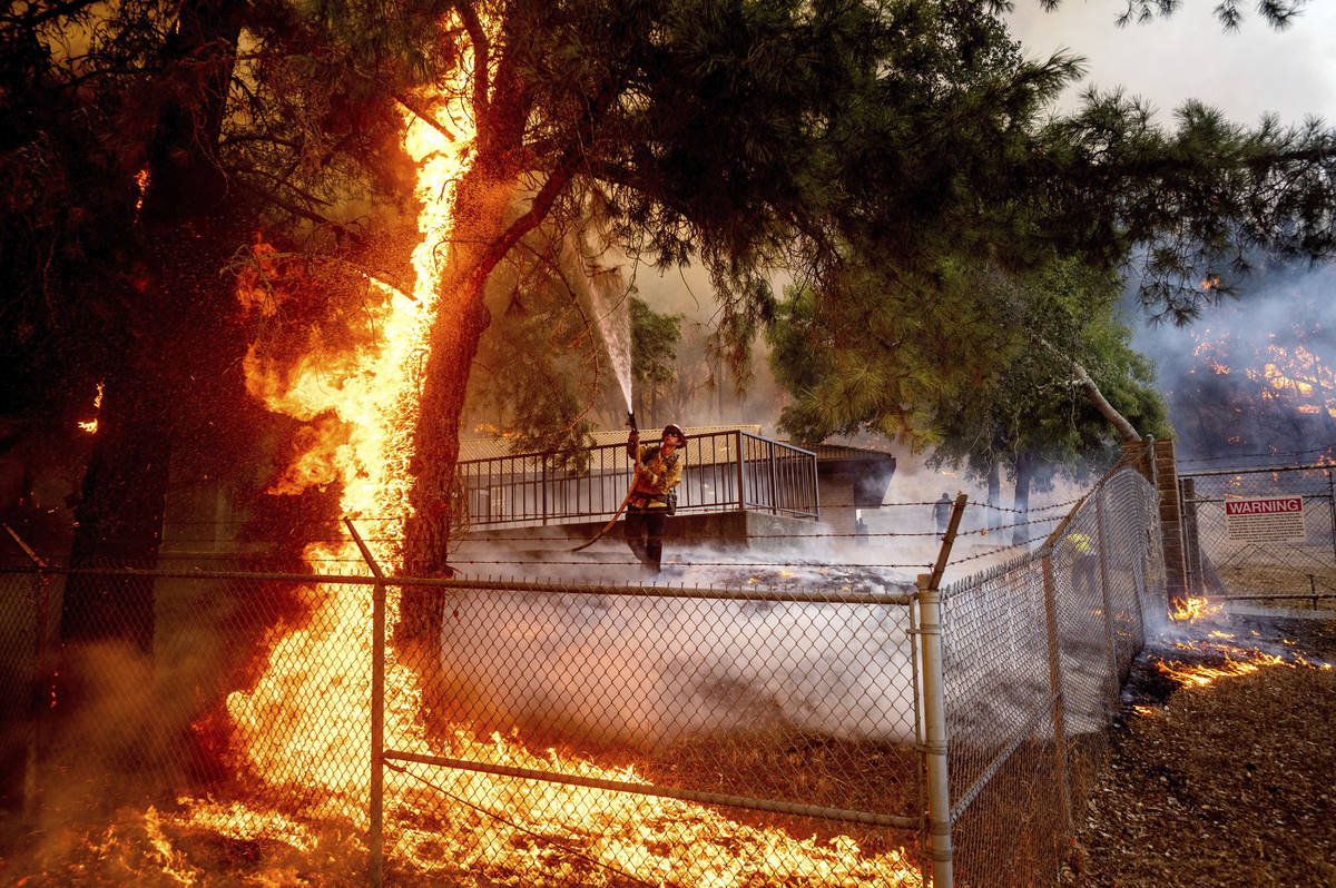 Cal Fire Capt. Jesse Campbell works to save the Louis Stralla Water Treatment Plant as the Glas ...