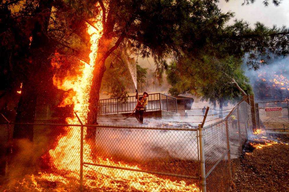Cal Fire Capt. Jesse Campbell works to save the Louis Stralla Water Treatment Plant as the Glas ...