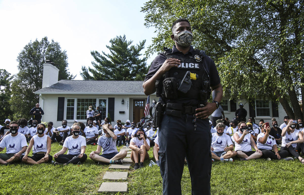 In this image from video, a Louisville Metro Police Department office stands guard outside the ...