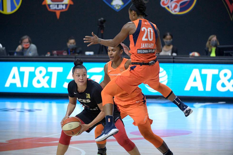 Las Vegas Aces guard Kayla McBride looks to pass the ball while defended by Connecticut Sun for ...
