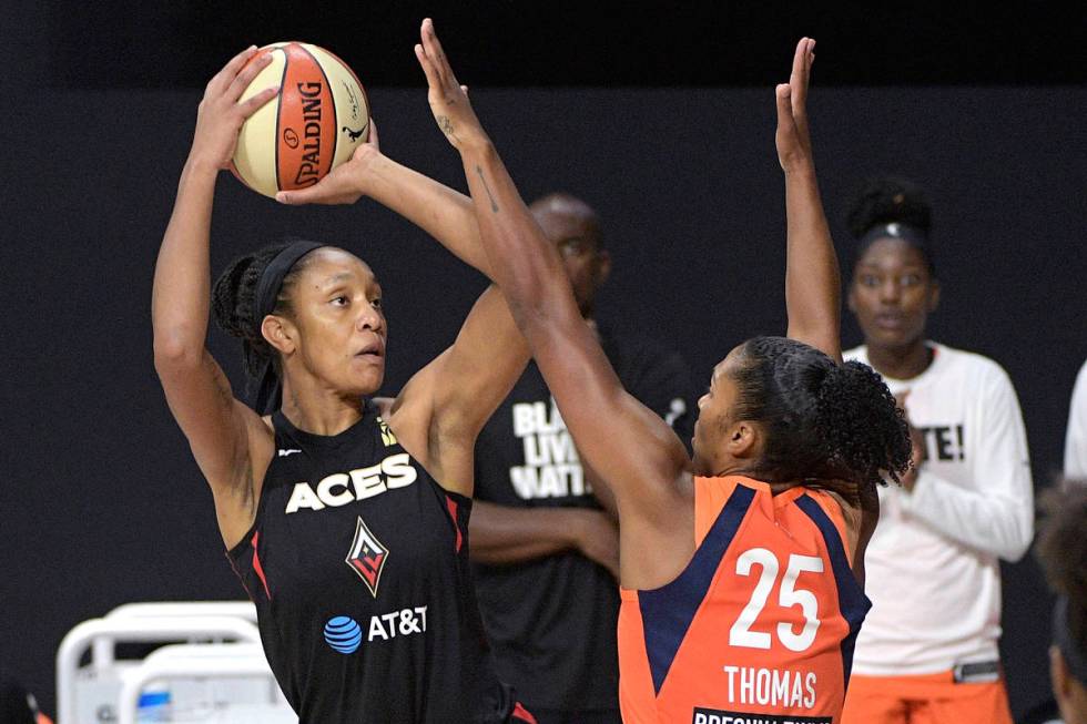 Las Vegas Aces center A'ja Wilson, left, goes up for a shot in front of Connecticut Sun forward ...