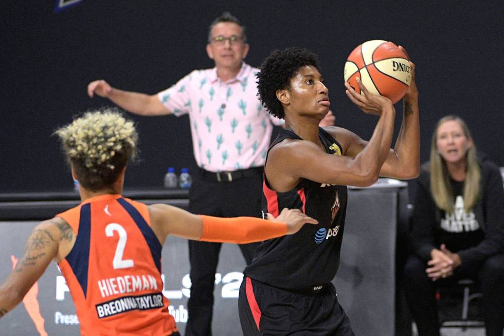 Las Vegas Aces forward Angel McCoughtry, right, sets up for a shot in front of Connecticut Sun ...