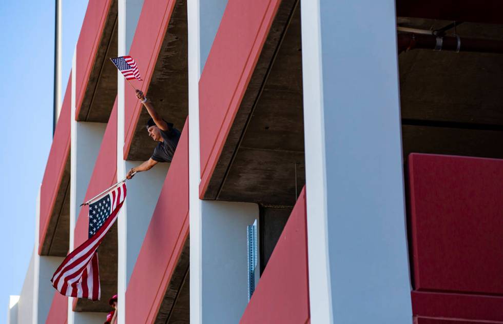 A man waves flags from the parking garage of the Ahern Hotel as supporters of law enforcement a ...