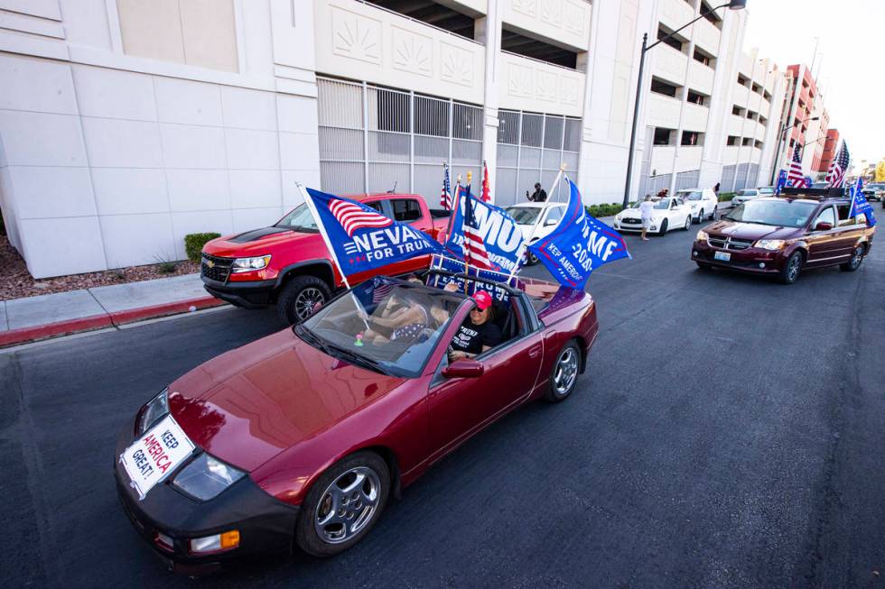 Helen McDonald, of Las Vegas, right, drives her car at the start of a parade in support of law ...