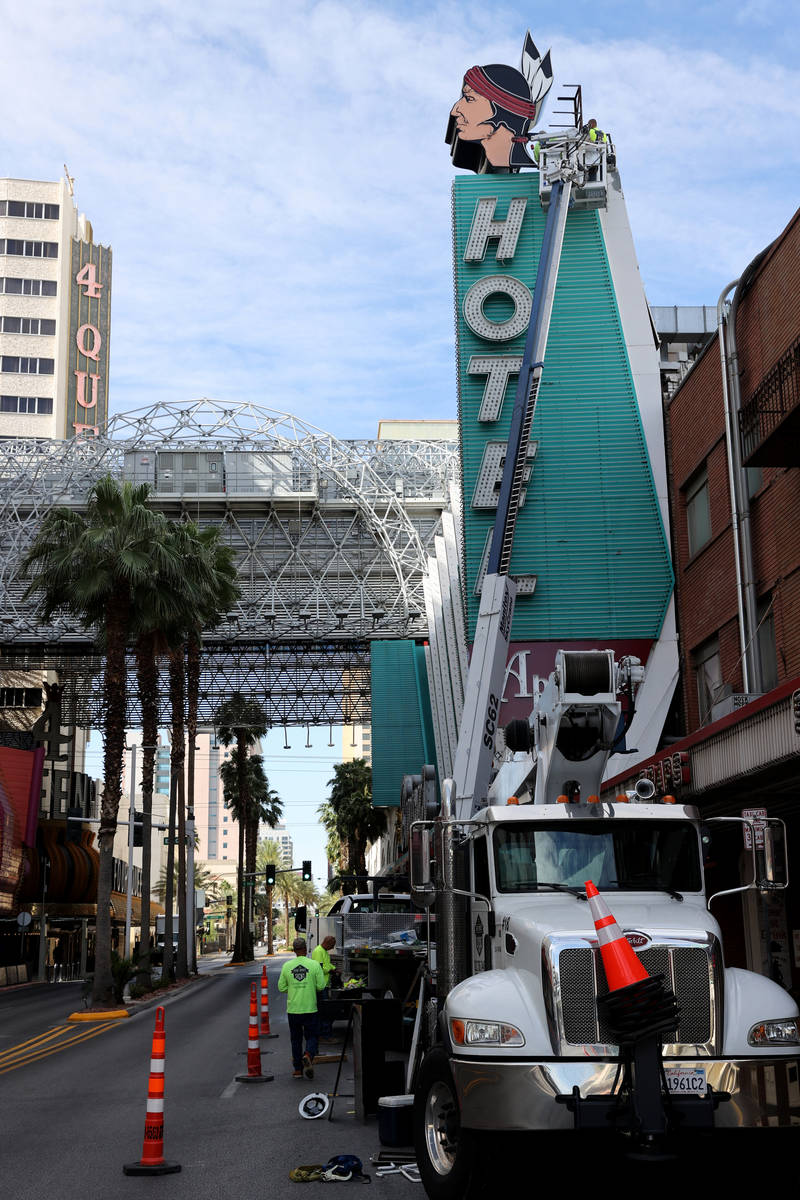 Workers install a new neon addition atop a sign at Hotel Apache at Binion's on Fremont Street a ...