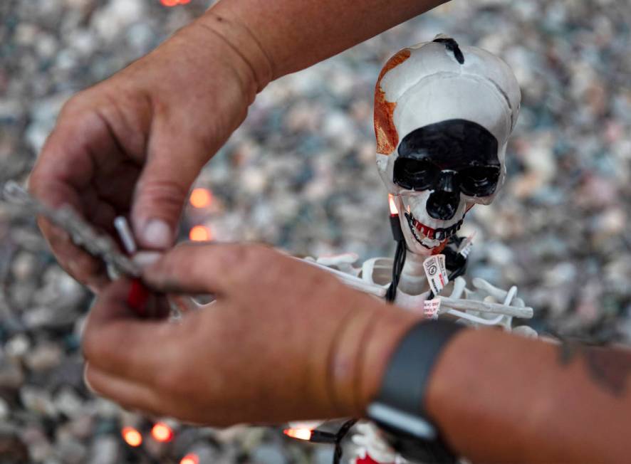 Tony Fronius adjusts a decorative skeleton in his front yard in Las Vegas, Sunday, Sept. 27, 20 ...