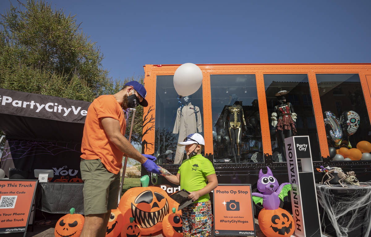 Steven Arnold tour manager for Hey Boo You Party City Mobile tour, left, gives a free goodie ba ...