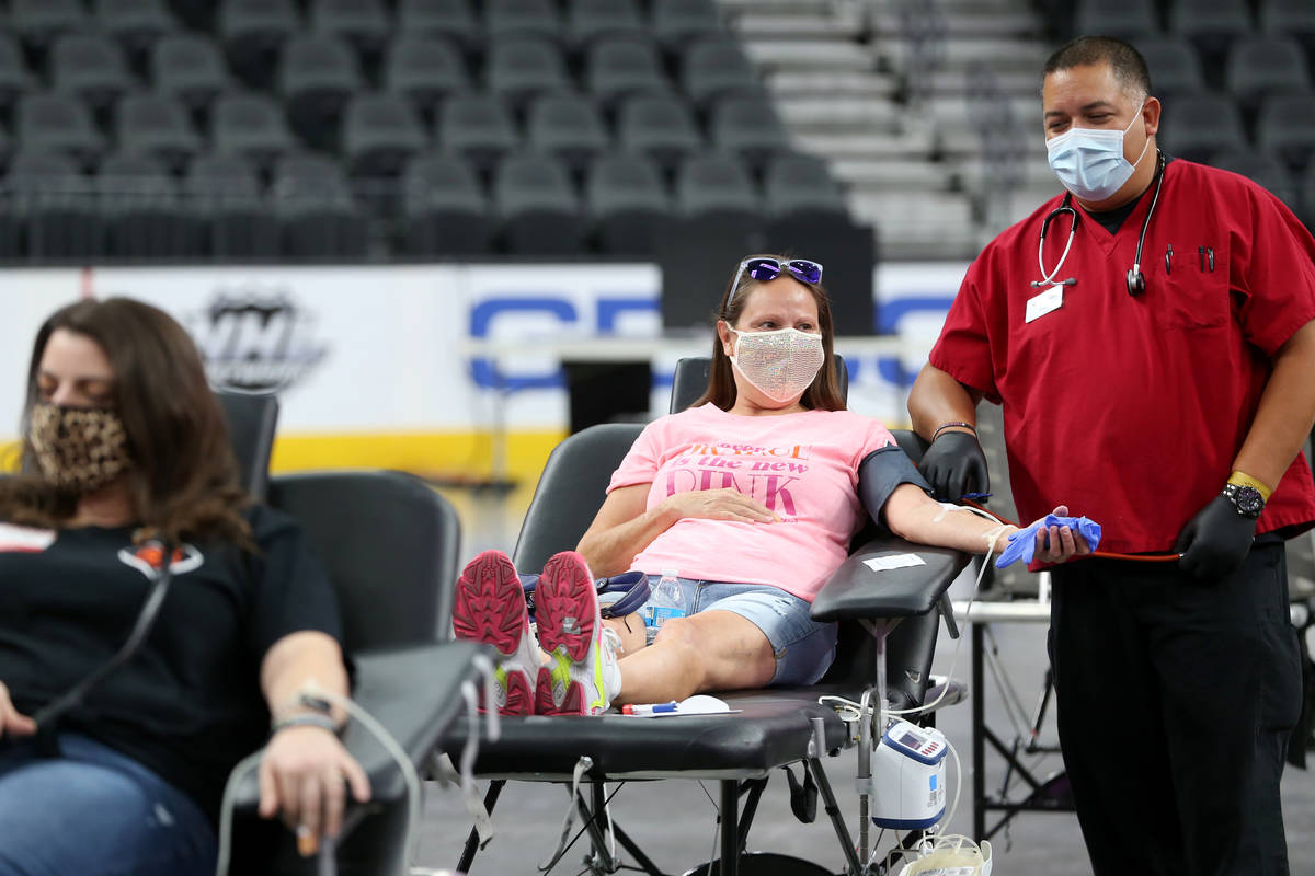 April Hiett of Las Vegas, center, gets her blood drawn by phlebotomist Dan Perez during a blood ...