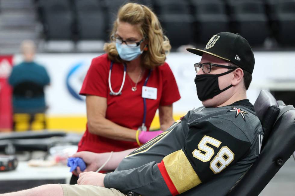 Zach Mueller of Las Vegas, right, gets his blood drawn by American Red Cross team lead Lisa Bra ...