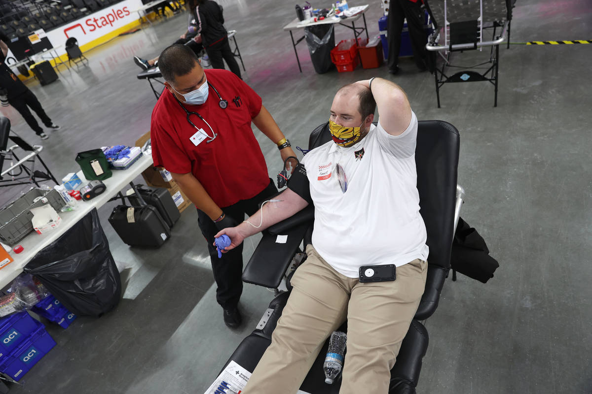 Everett Duke of Las Vegas, right, gets his blood drawn by phlebotomist Dan Perez during a blood ...