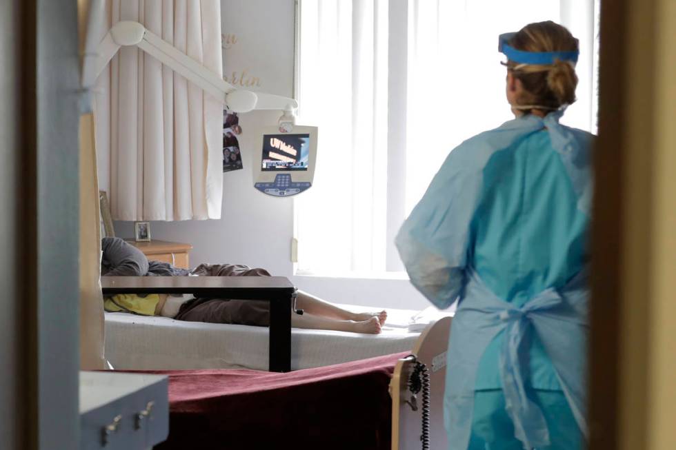 A health worker arrives to take a nose swab sample at a nursing and rehabilitation facility in ...