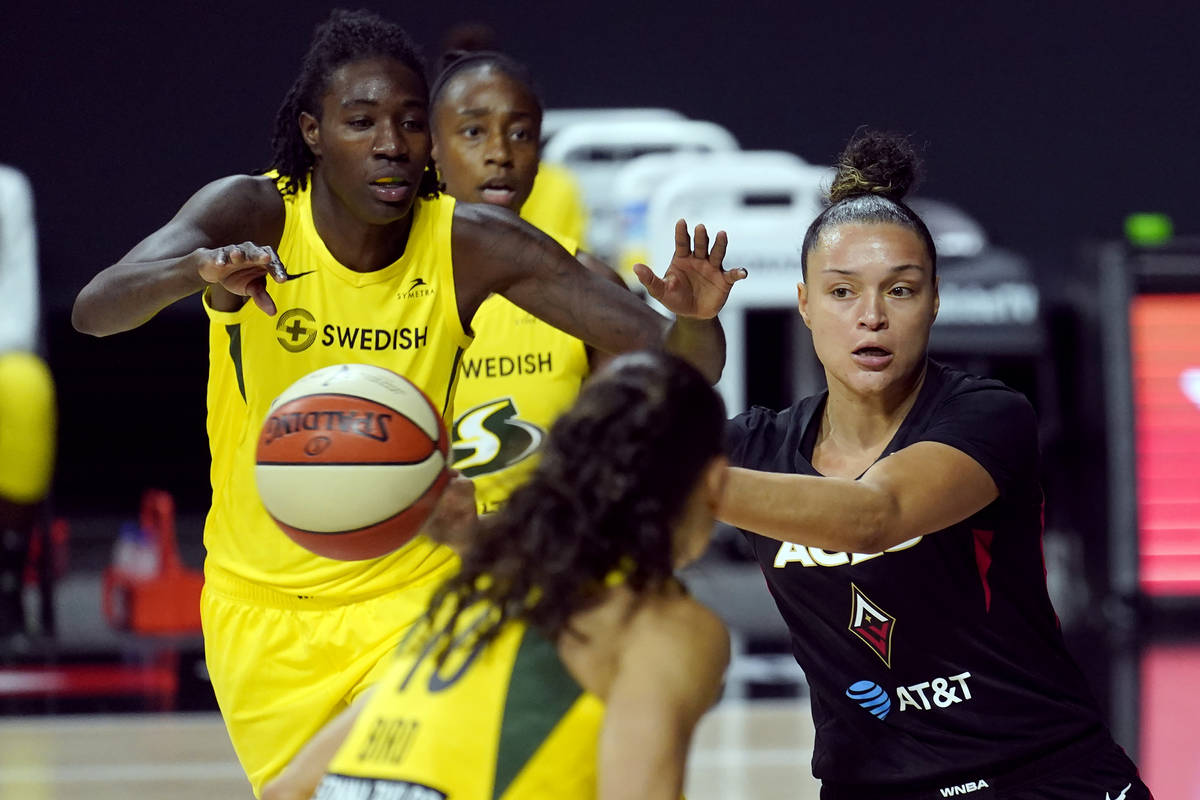 Las Vegas Aces guard Kayla McBride passes the ball after getting around Seattle Storm forward N ...