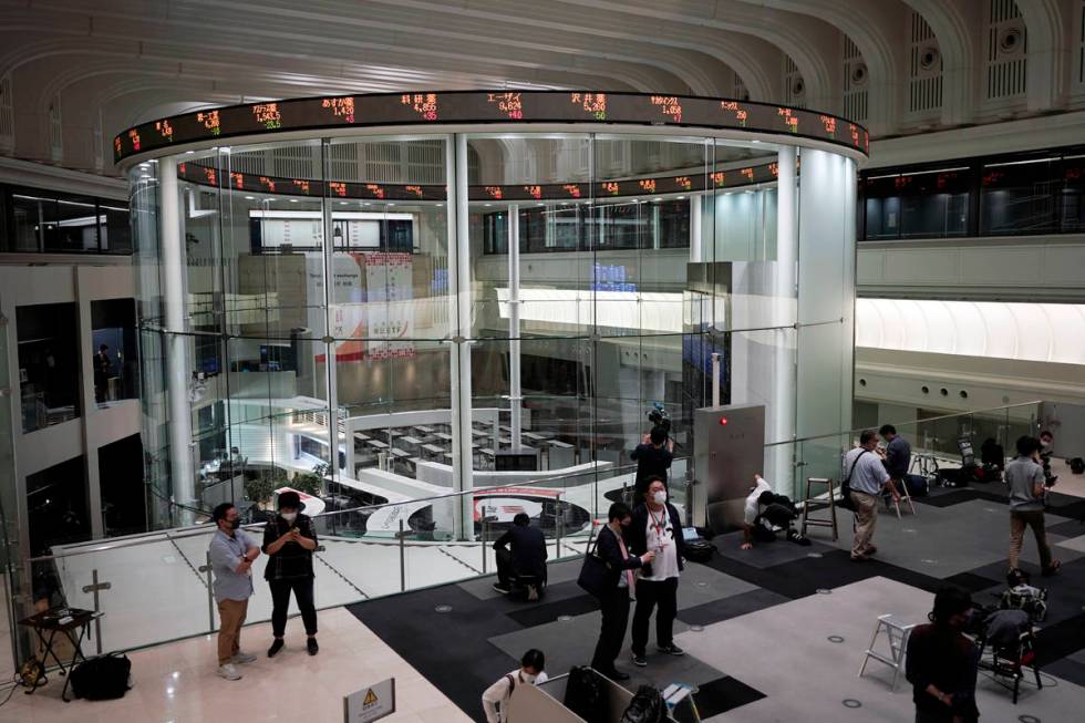 Journalists film an electronic stock board showing reopened Japan's Nikkei 225 index at Tokyo S ...