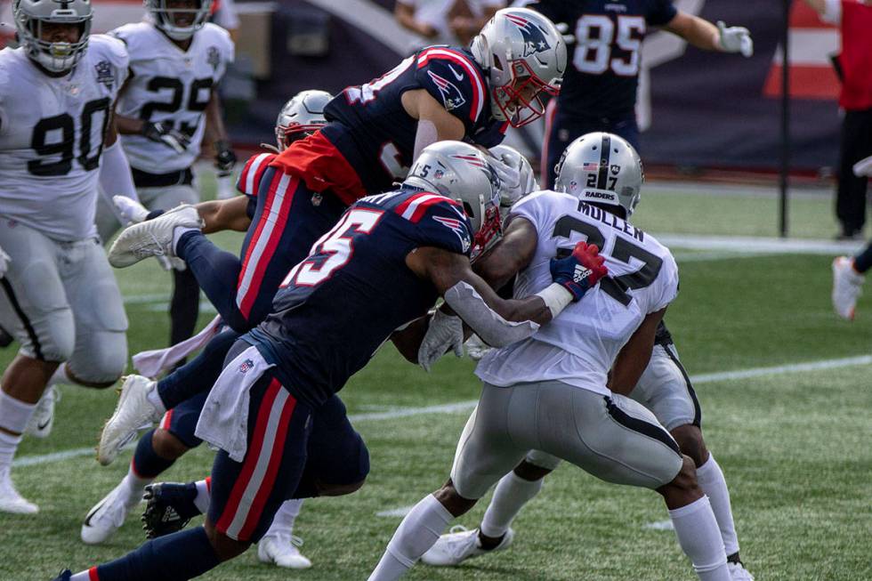 New England Patriots running back Rex Burkhead (34) leaps over Las Vegas Raiders cornerback Tra ...