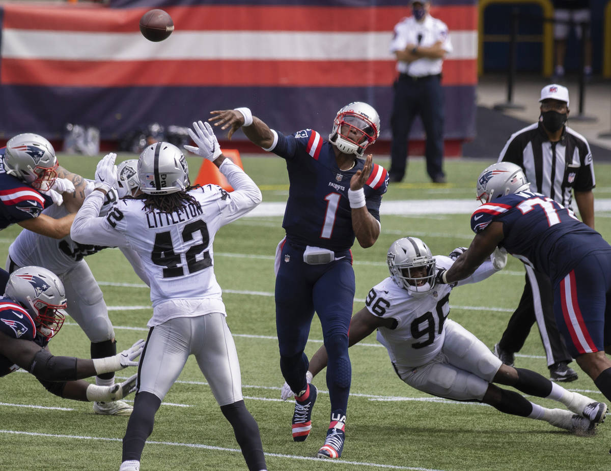 New England Patriots quarterback Cam Newton (1) avoids the pass rush of Las Vegas Raiders defen ...