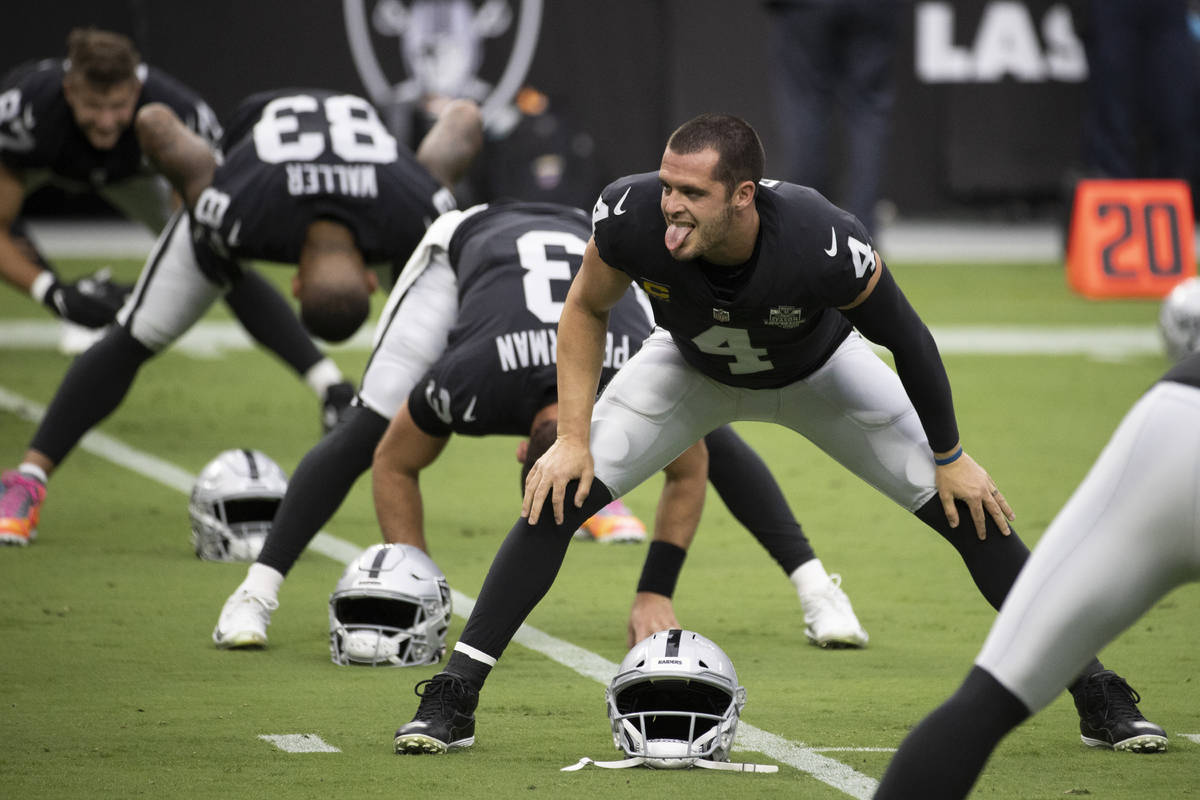 Las Vegas Raiders quarterback Derek Carr (4) jokes around with teammates during warms up before ...