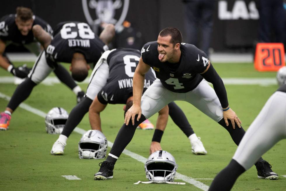 Las Vegas Raiders quarterback Derek Carr (4) jokes around with teammates during warms up before ...