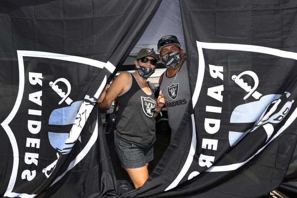 Maria Morales, left, and her husband Lorenzo Morales pose during a tailgate before an NFL footb ...