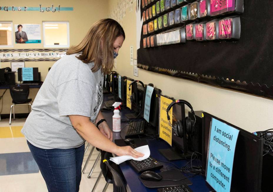 Jackie Justice, technology specialist, sanitizes computers at Somerset Academy Sky Pointe as sh ...