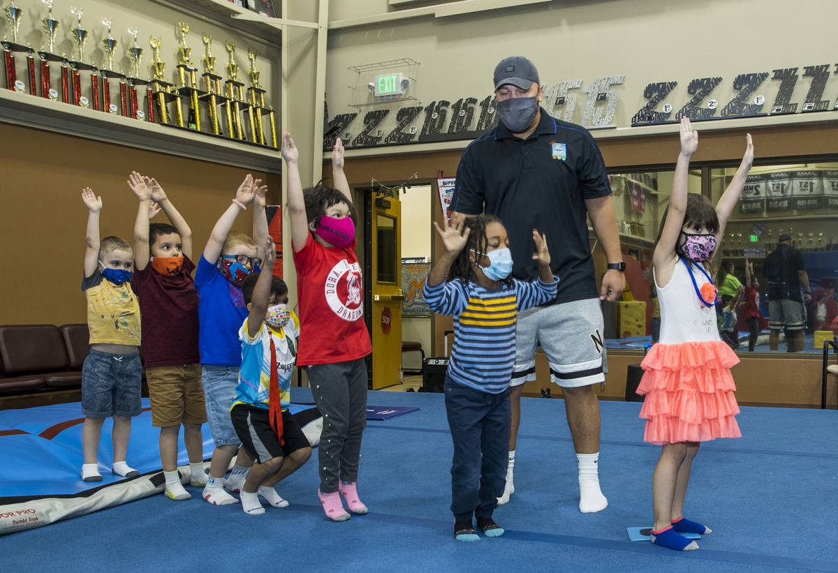 Instructor Mo Bonnet, center, encourages kindergarteners in standing jumps while exercising dur ...