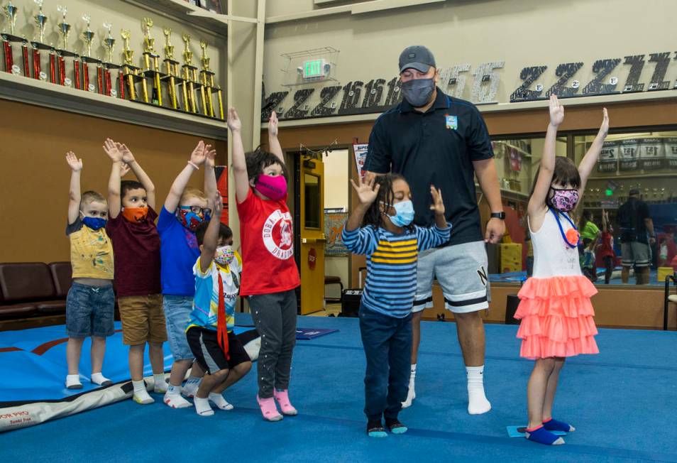 Instructor Mo Bonnet, center, encourages kindergarteners in standing jumps while exercising dur ...