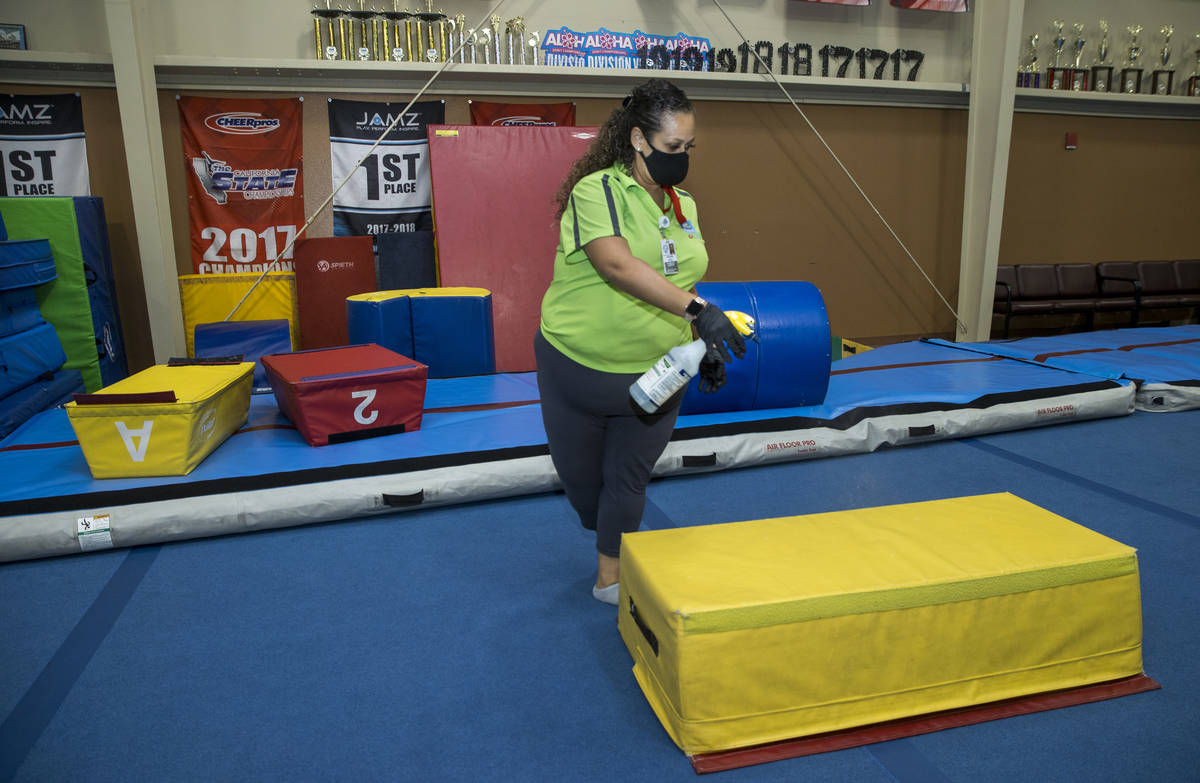 Recreation coordinator Priscilla Scott sanitizes gym mats after kindergartnerÕs finish an ...