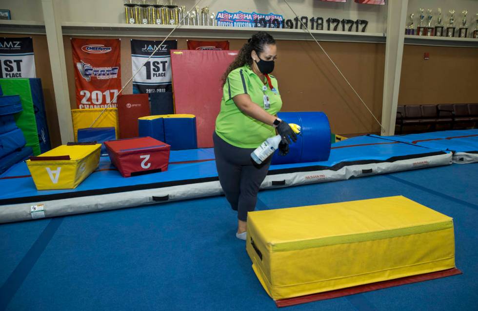 Recreation coordinator Priscilla Scott sanitizes gym mats after kindergartnerÕs finish an ...