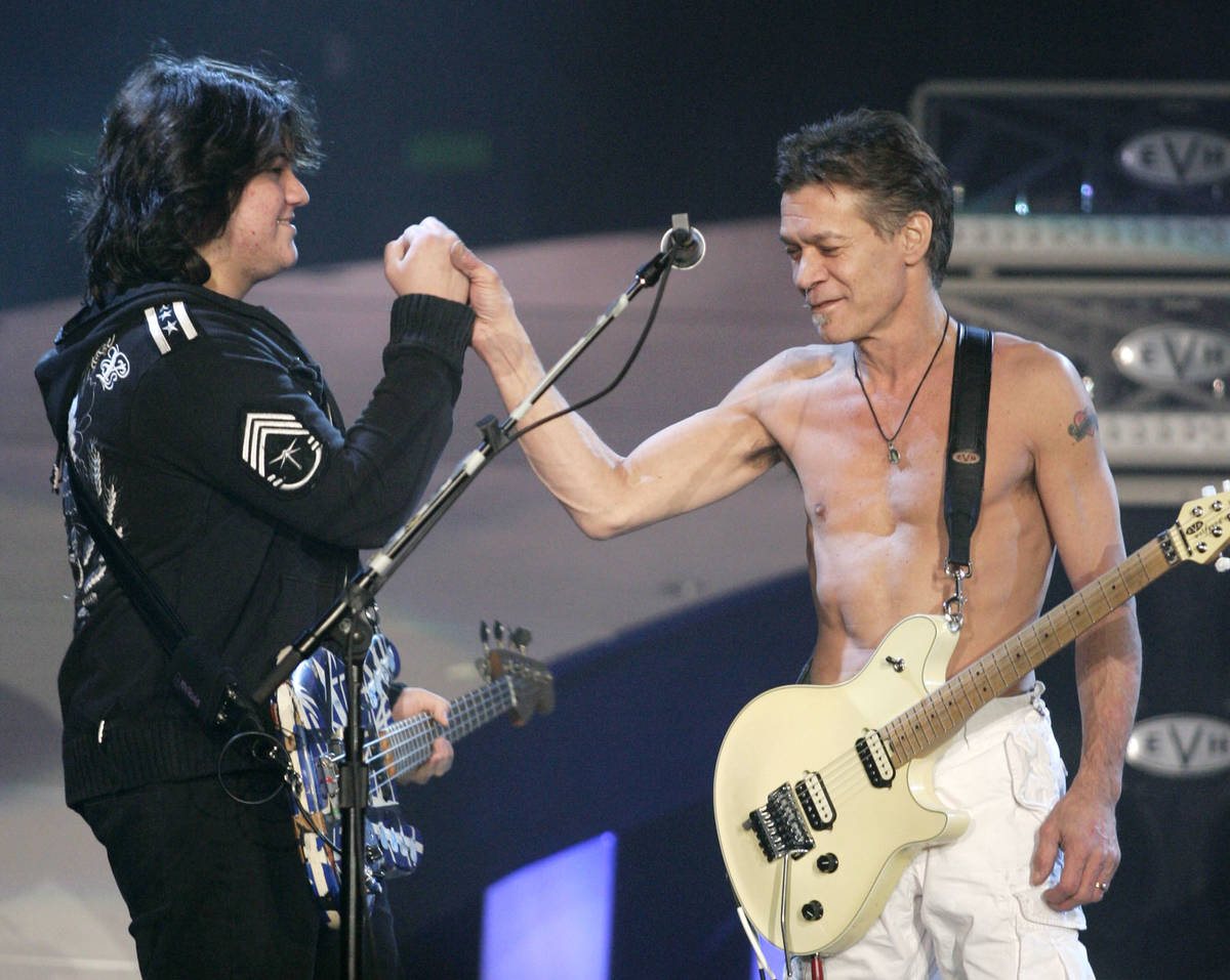 Wolfgang Van Halen, left, clasps hands with his rock star dad Eddie Van Halen during a performa ...