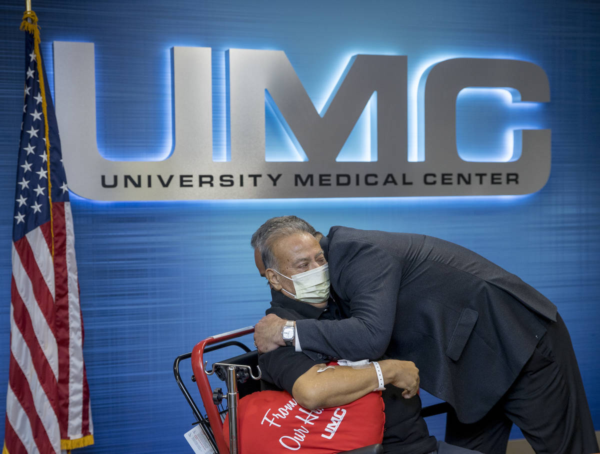 Pablo Bernabe, left, hugs University Medical Center CEO Mason Van Houweling, right, during a pr ...