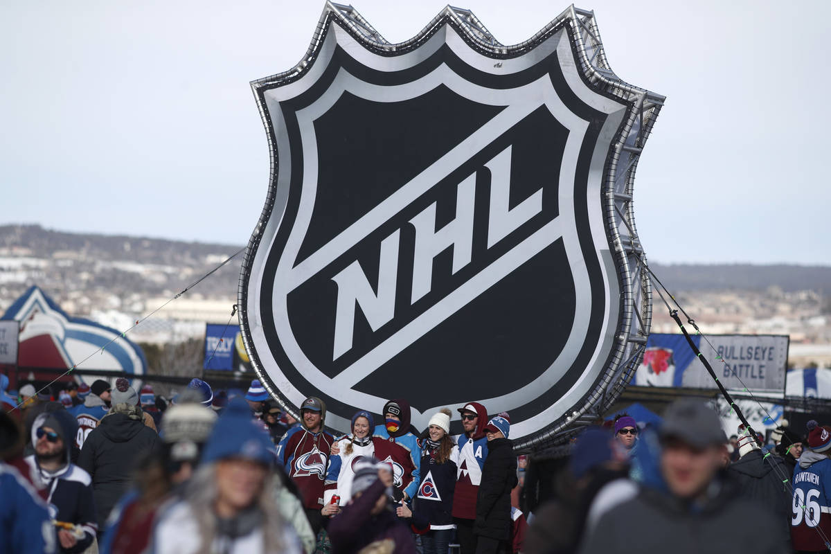In this Feb. 15, 2020, file photo, fans pose below the NHL league logo at a display outside Fal ...