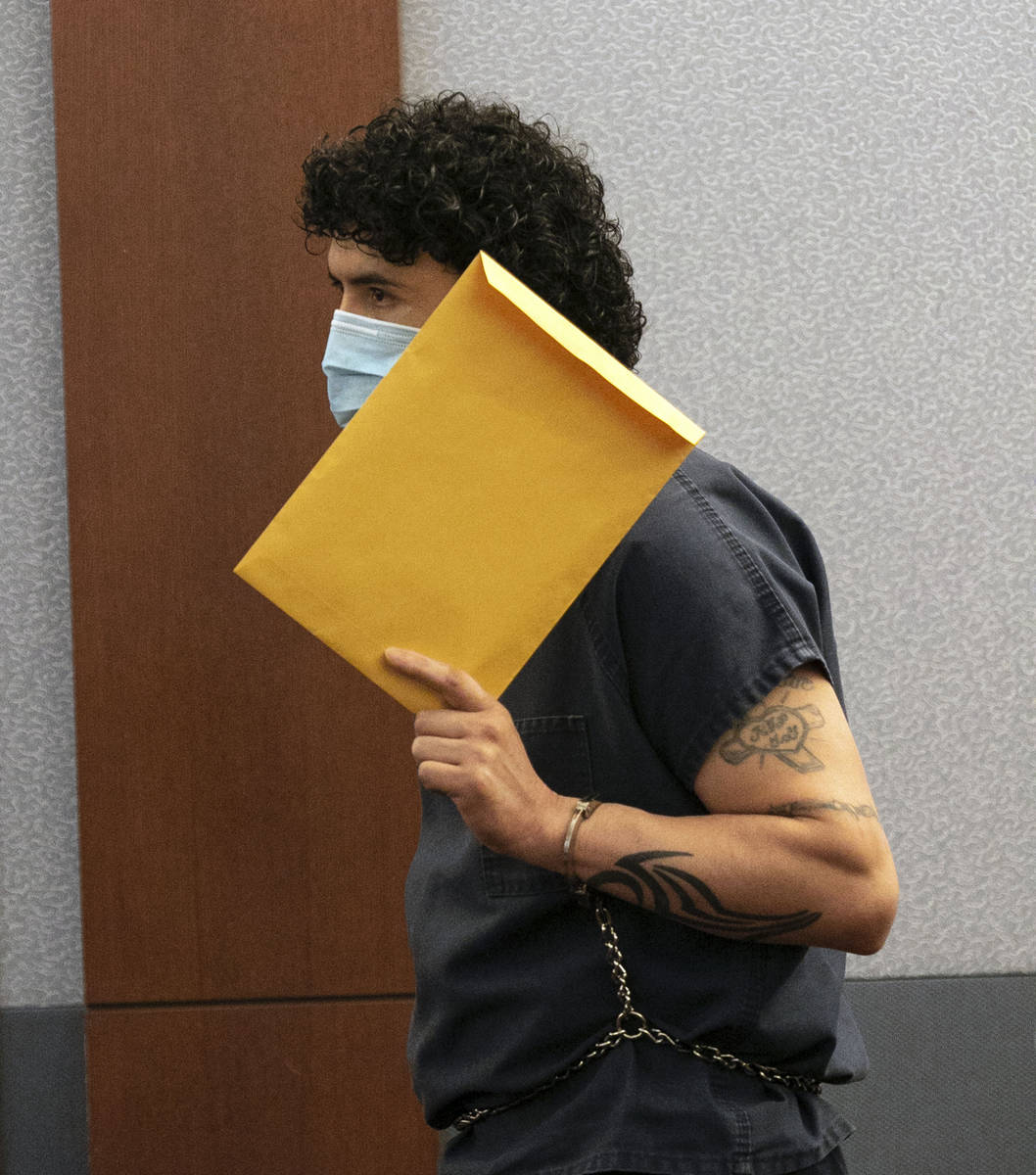 Silvino Hinojosa hides his face during a brief hearing at the Regional Justice Center, on Tuesd ...