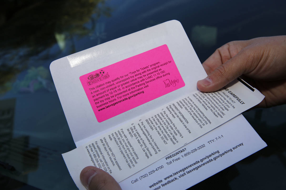 In this Nov. 22, 2016, file photo, Parking Enforcement Officer Logan Williams shows a parking t ...