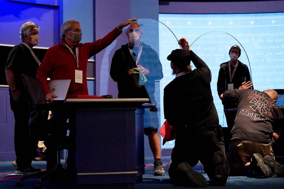 Members of the production crew inspect glass on stage which will serve as a barrier to protect ...