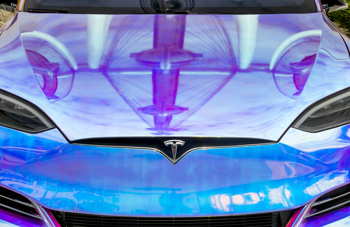 The High Roller is reflected on the hood of a Tesla parked in the Tesla Supercharger station ne ...