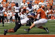 Texas wide receiver Jake Smith (7) is hit by TCU safety Ar'Darius Washington (24) as he makes a ...