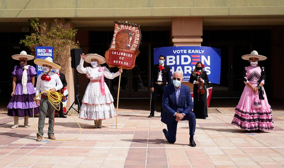 Democratic presidential candidate former Vice President Joe Biden takes a knee as he poses for ...